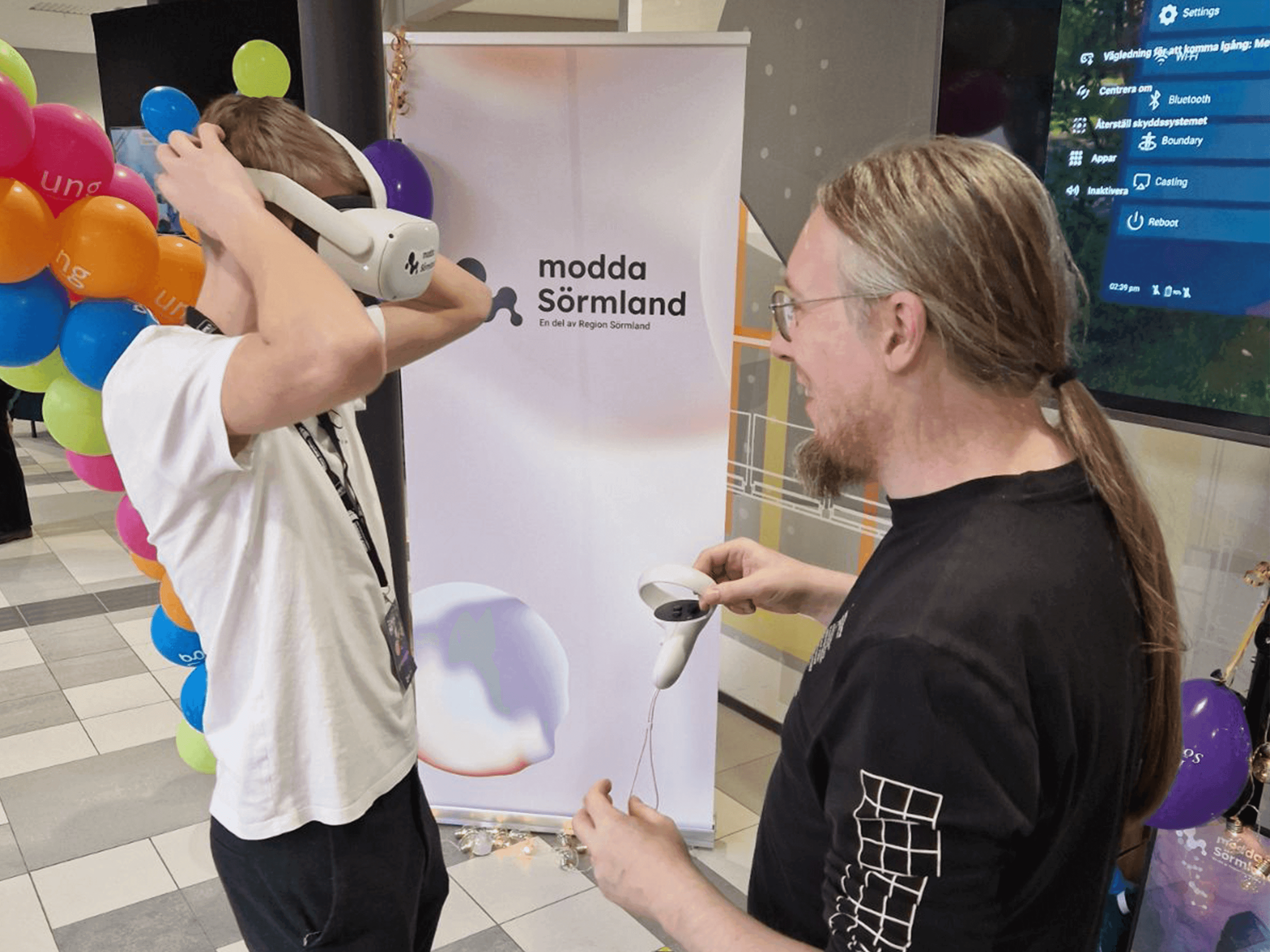 Petter Danielsson hjälper ett barn med VR headset