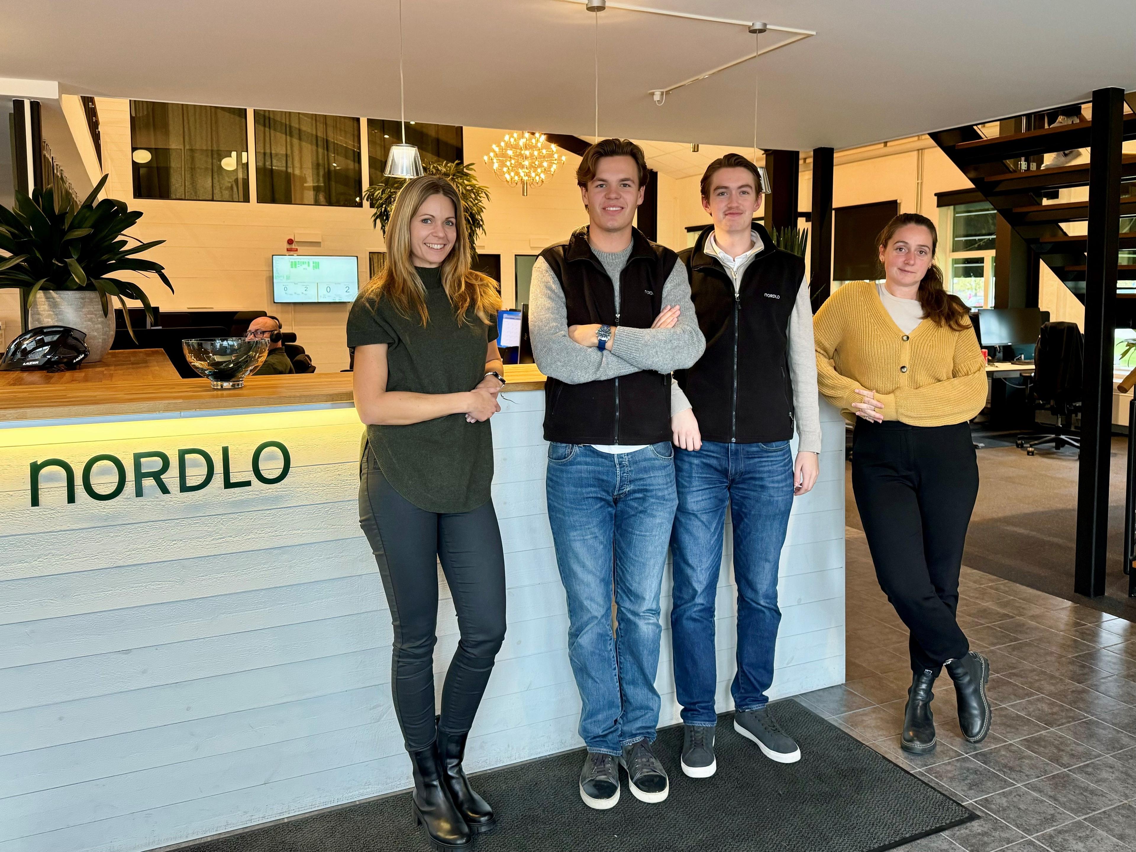 Personer framför en informationsdesk med texten Nordlo på