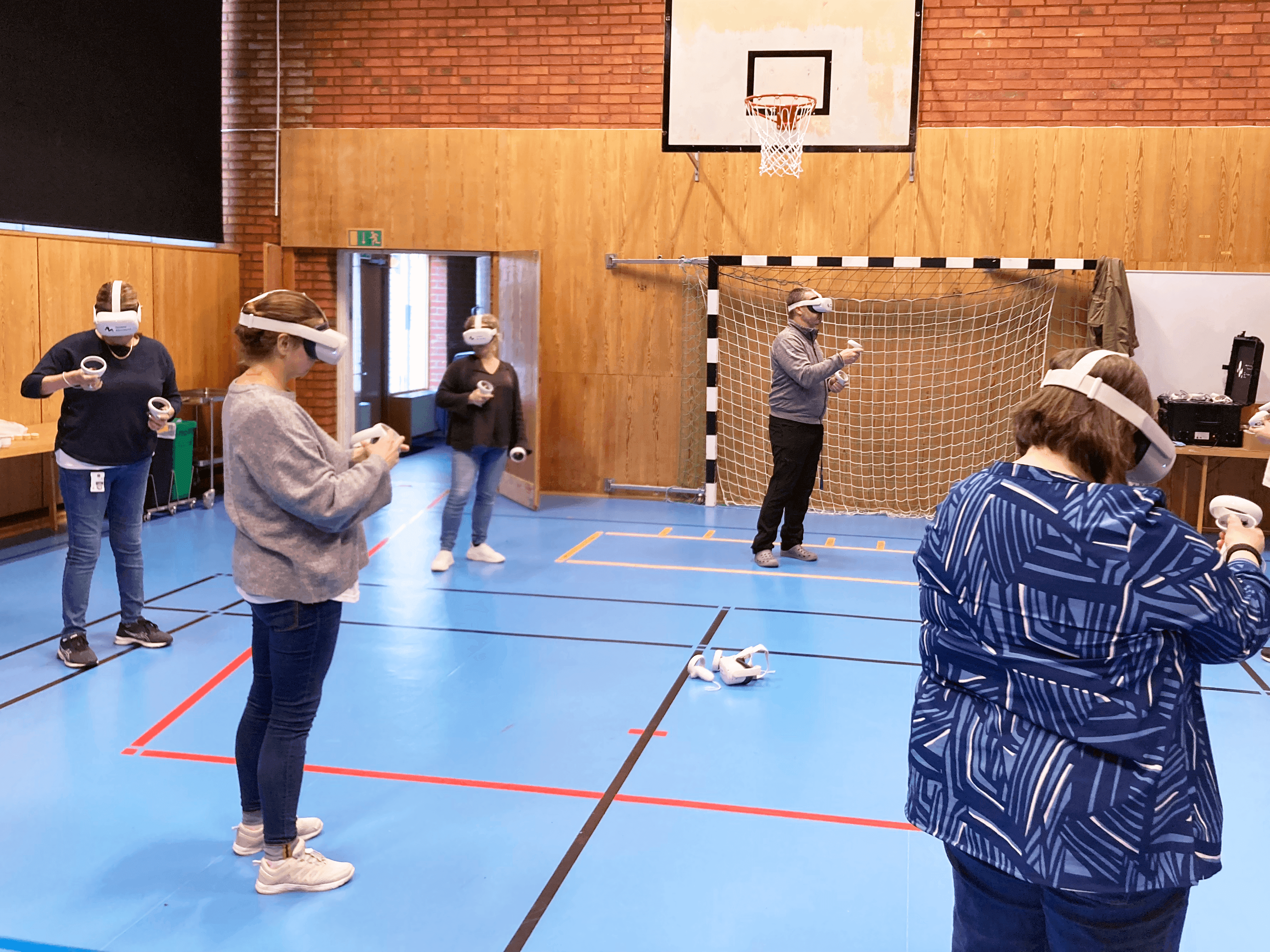 Flera personer i en gymnastiksal som har VR utrustning på sig