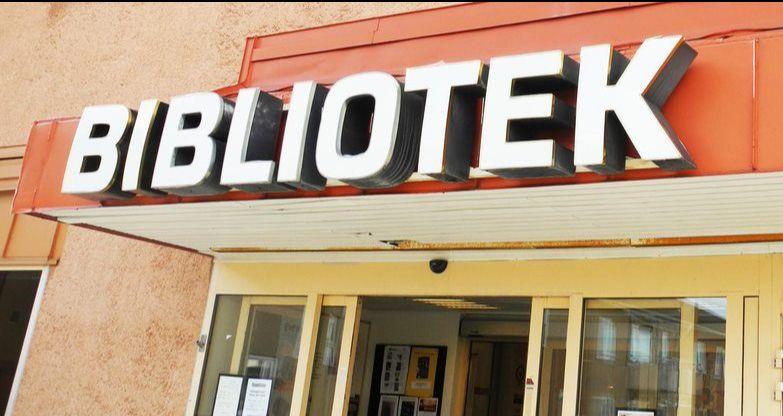 Bild på en biblioteksskylt ovanför en entredörr