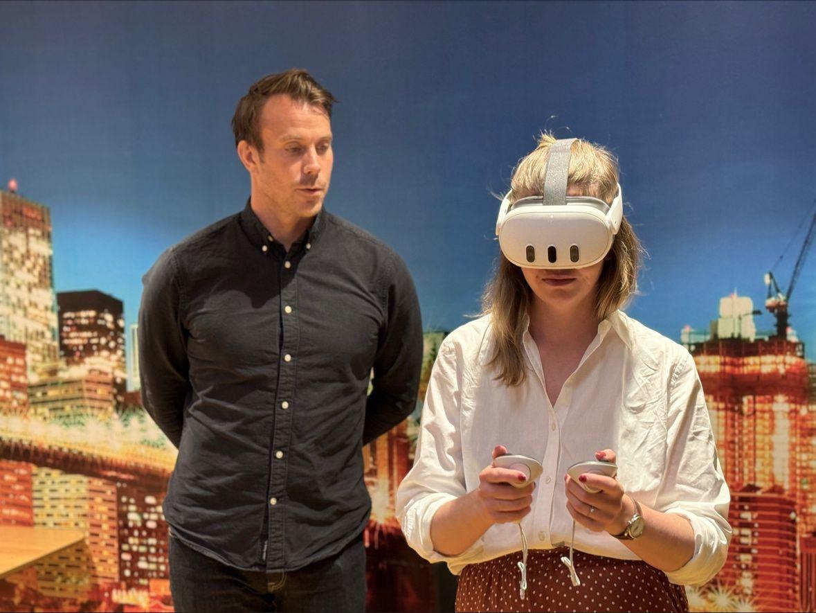 En man står bredvid en kvinna i VR headset