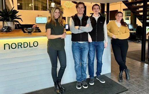 Personer framför en informationsdesk med texten Nordlo på
