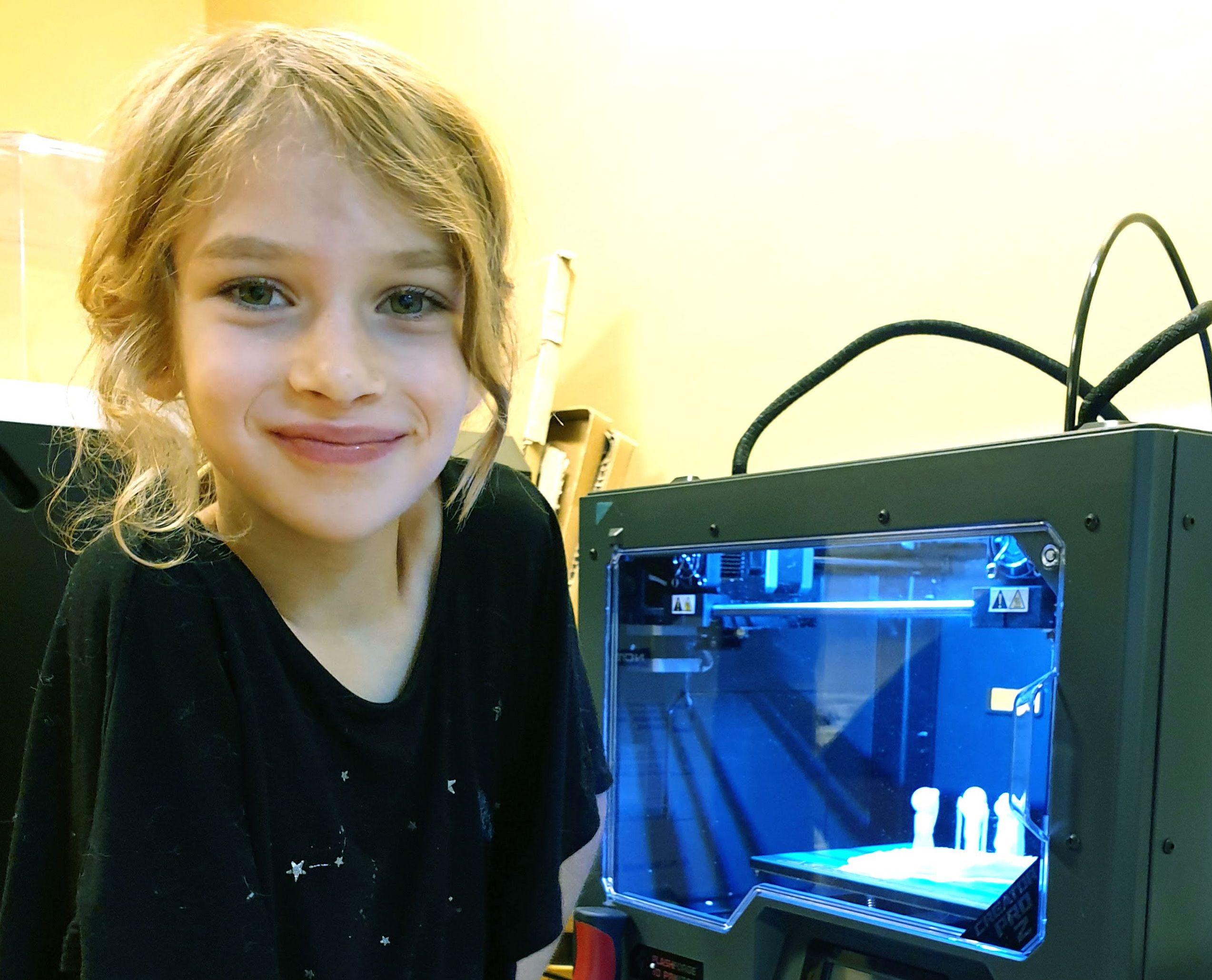 En flicka som sitter vi den 3D skrivare