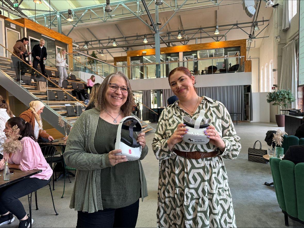 Två kvinnor håller var sitt VR headset.